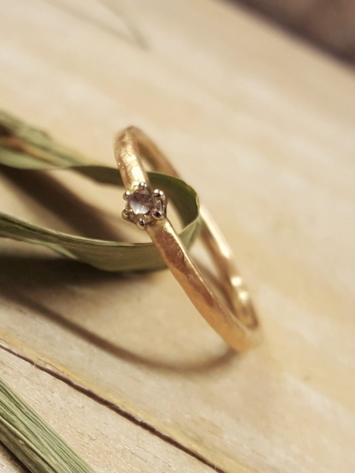 Verlobungsring in mattem Gelbgold mit weißem großen Brillanten.