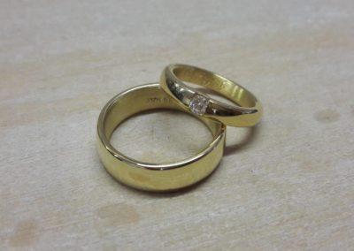 Rundlich gewölbte Trauringe in glänzendem Gelbgold mit Brillant.