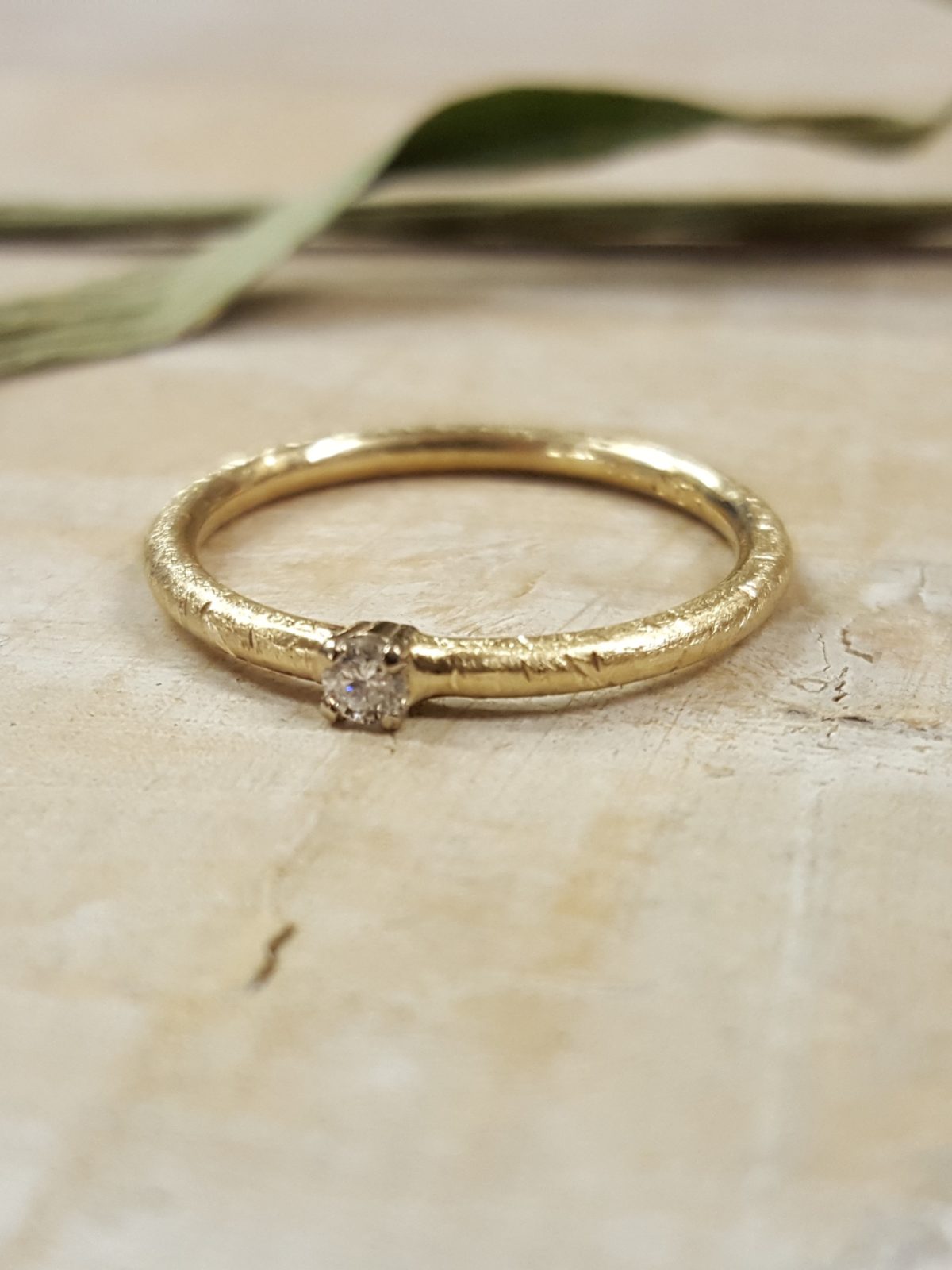 Verlobungsring in mattem Gelbgold mit weißem großen Brillanten.