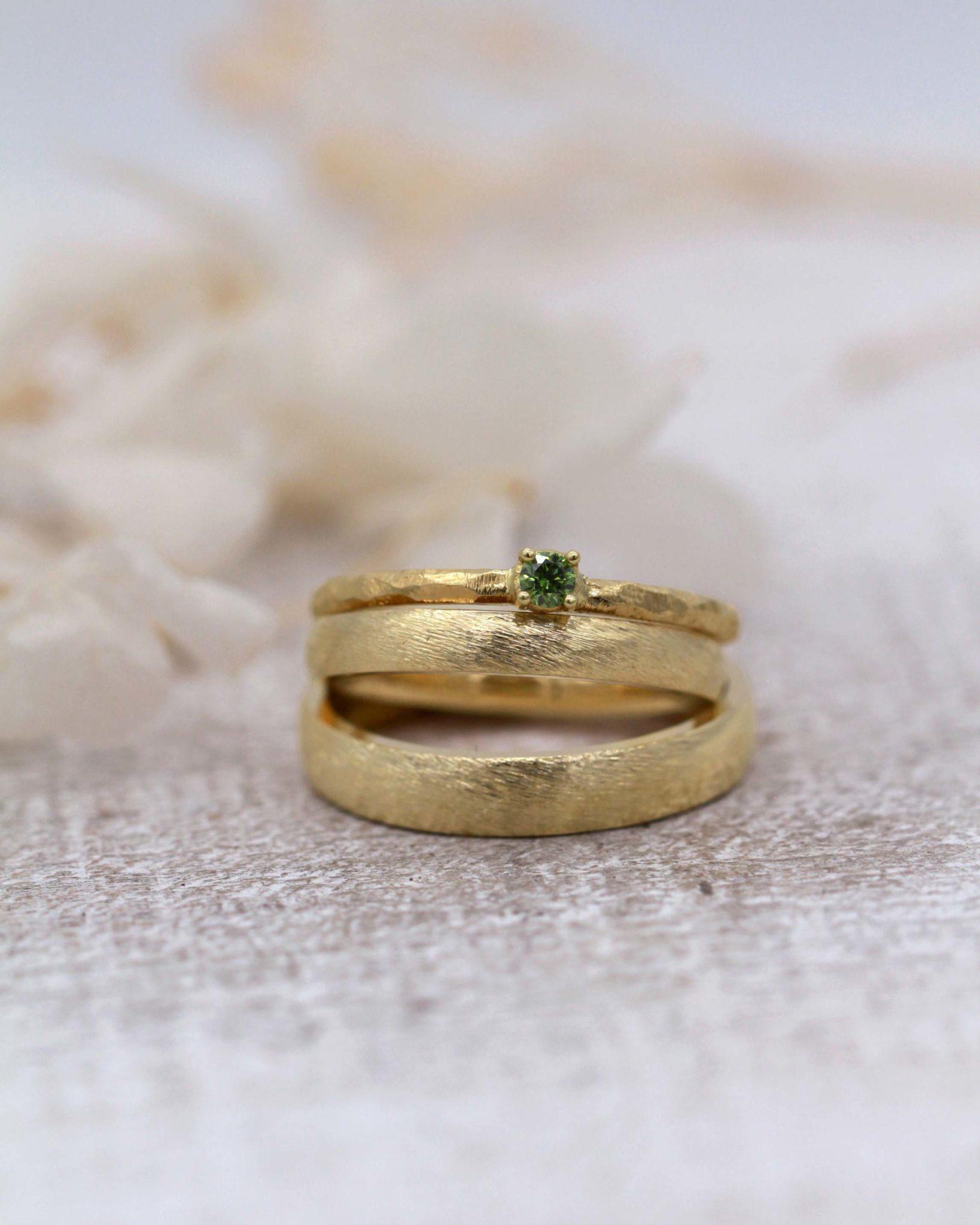 Verlobungsring mit grünem Stein Olivi und Trauringe mit Dünemuster